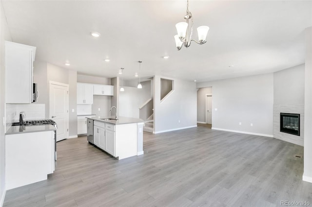 kitchen featuring sink, pendant lighting, white cabinetry, and a kitchen island with sink