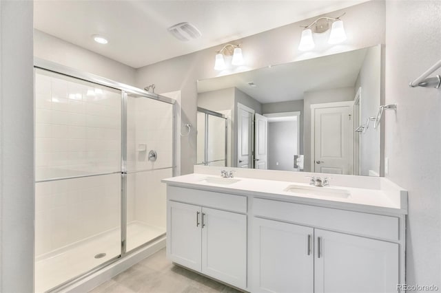 bathroom featuring a shower with door, vanity, and tile patterned flooring