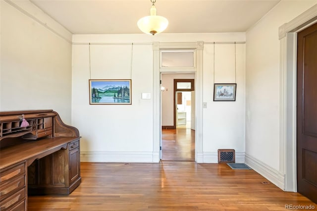 interior space with light wood-style floors, visible vents, and baseboards