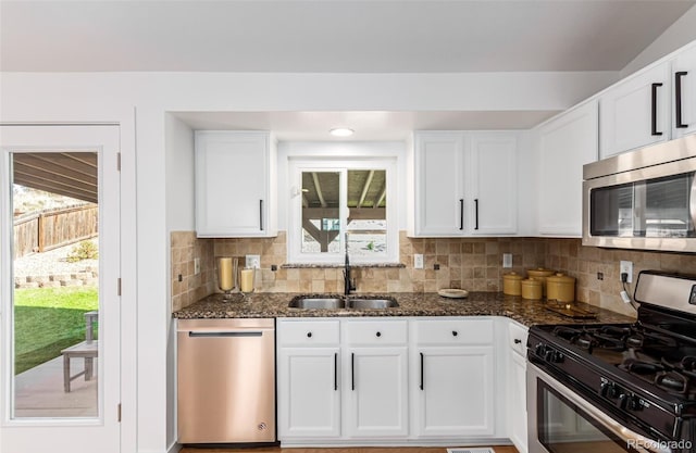 kitchen featuring sink, white cabinetry, appliances with stainless steel finishes, and dark stone countertops