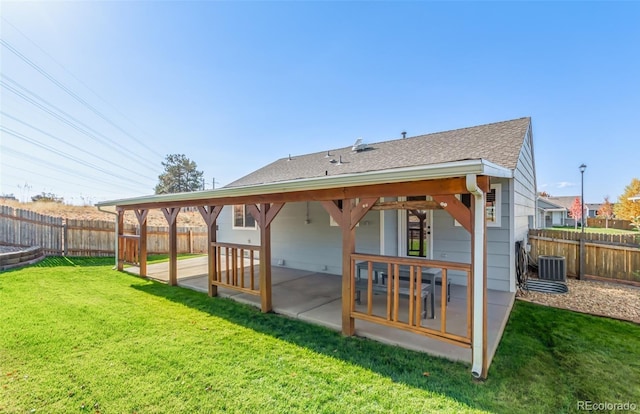 rear view of house with a patio area, cooling unit, and a yard