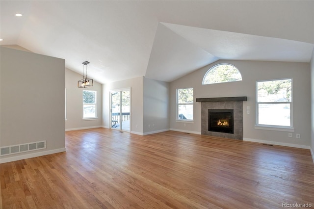 27627 E Broadview Dr, Kiowa, CO 80117 - unfurnished living room featuring lofted ceiling, light wood-type flooring, a tile fireplace, plenty of natural light, and baseboards