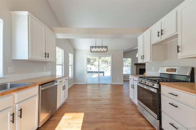 27627 E Broadview Dr, Kiowa, CO 80117 - kitchen featuring stainless steel appliances, vaulted ceiling, light wood-style floors, white cabinetry, and light countertops