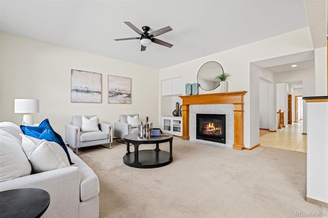 carpeted living area with ceiling fan, a fireplace, and tile patterned floors