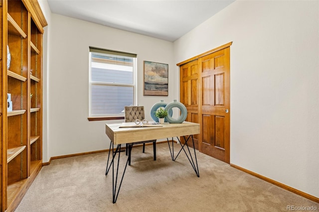 office space featuring light carpet and baseboards