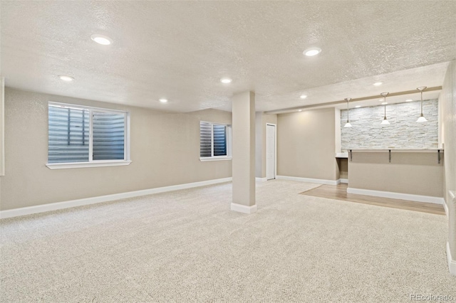 finished basement with carpet, a textured ceiling, and recessed lighting