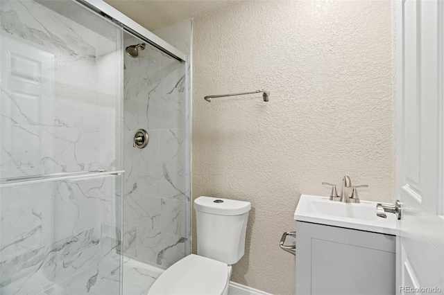 bathroom featuring toilet, a marble finish shower, vanity, and a textured wall