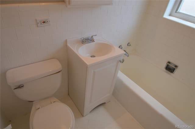 bathroom featuring tile walls, vanity, toilet, a bath, and tile patterned floors