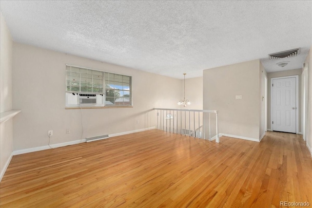 6721 Quay Ct, Arvada, CO 80003 - spare room featuring wood finished floors, a chandelier, a textured ceiling, and cooling unit