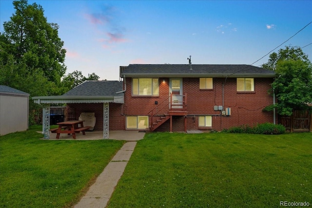 6721 Quay Ct, Arvada, CO 80003 - back of house at dusk featuring a patio, stairs, brick siding, and roof with shingles