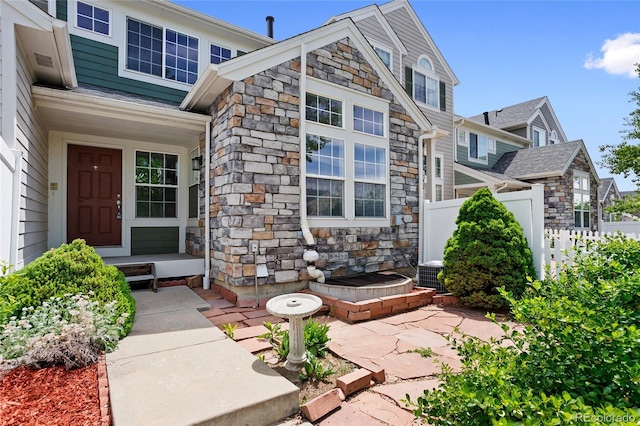 14247 Pikeminnow Pl, Broomfield, CO 80023 - view of exterior entry with stone siding, fence, and central air condition unit