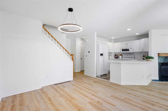 14247 Pikeminnow Pl, Broomfield, CO 80023 - kitchen with white appliances, light wood-style floors, light countertops, decorative backsplash, and recessed lighting
