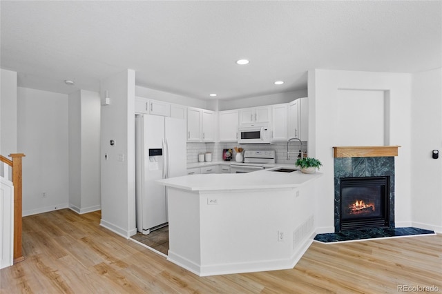 14247 Pikeminnow Pl, Broomfield, CO 80023 - kitchen with white appliances, a sink, light wood finished floors, white cabinetry, and light countertops