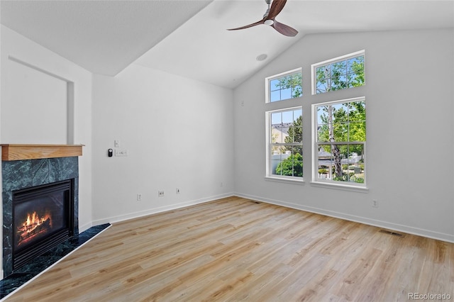 14247 Pikeminnow Pl, Broomfield, CO 80023 - unfurnished living room featuring a premium fireplace, a ceiling fan, wood finished floors, baseboards, and high vaulted ceiling