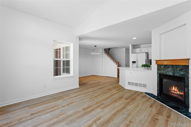 14247 Pikeminnow Pl, Broomfield, CO 80023 - unfurnished living room featuring light wood-type flooring, a high end fireplace, baseboards, stairs, and recessed lighting