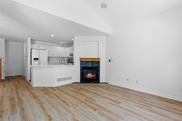 14247 Pikeminnow Pl, Broomfield, CO 80023 - unfurnished living room with a fireplace, light wood-style floors, baseboards, recessed lighting, and lofted ceiling