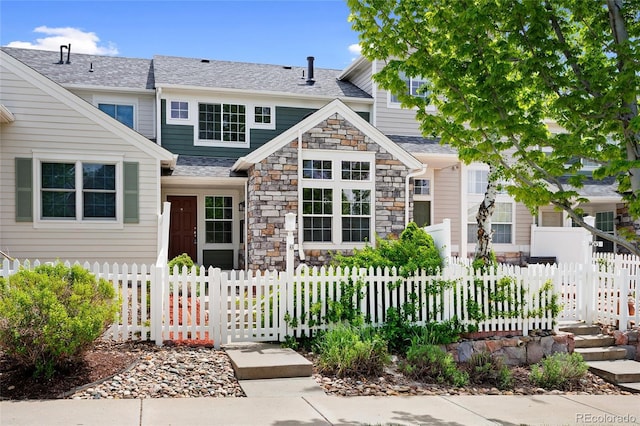 14247 Pikeminnow Pl, Broomfield, CO 80023 - view of front facade with a fenced front yard, stone siding, and roof with shingles