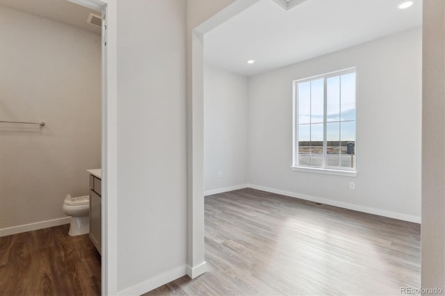 bathroom featuring hardwood / wood-style flooring, toilet, and vanity