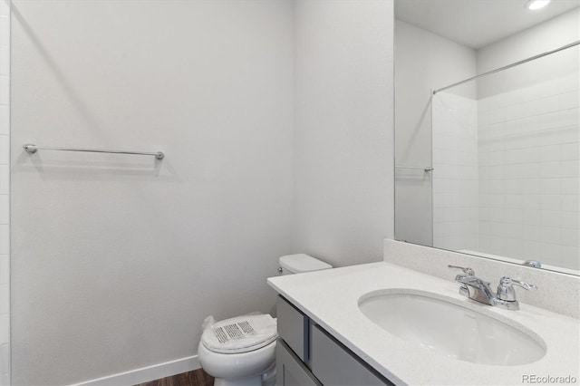 bathroom featuring hardwood / wood-style floors, toilet, vanity, and walk in shower