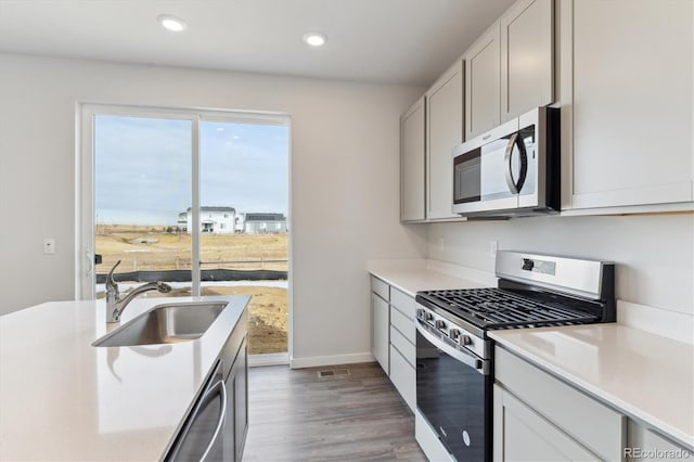 kitchen featuring sink, light hardwood / wood-style flooring, white cabinetry, and stainless steel appliances