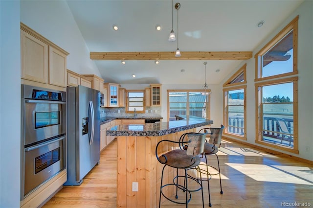 kitchen featuring pendant lighting, stainless steel appliances, and lofted ceiling with beams