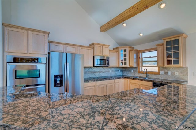 kitchen featuring appliances with stainless steel finishes, vaulted ceiling with beams, decorative backsplash, and sink