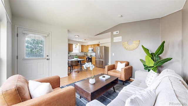 1670 S Deframe St Unit C2, Lakewood, CO 80228 - living room featuring vaulted ceiling and light wood-style floors