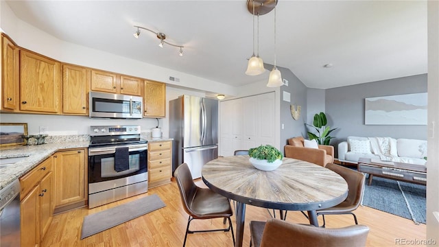 1670 S Deframe St Unit C2, Lakewood, CO 80228 - kitchen with stainless steel appliances, light wood-style flooring, light stone countertops, and hanging light fixtures