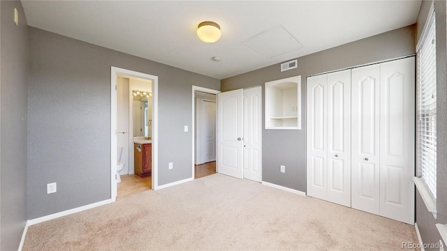 1670 S Deframe St Unit C2, Lakewood, CO 80228 - unfurnished bedroom with light colored carpet, two closets, baseboards, and connected bathroom