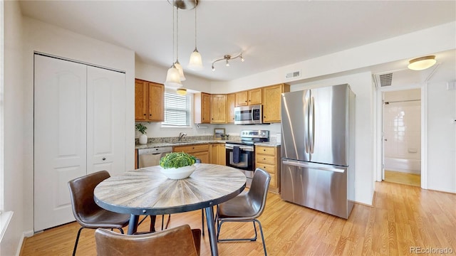 1670 S Deframe St Unit C2, Lakewood, CO 80228 - kitchen featuring stainless steel appliances, a sink, hanging light fixtures, and light wood finished floors