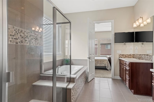 bathroom with plus walk in shower, tile patterned floors, a wealth of natural light, and vanity