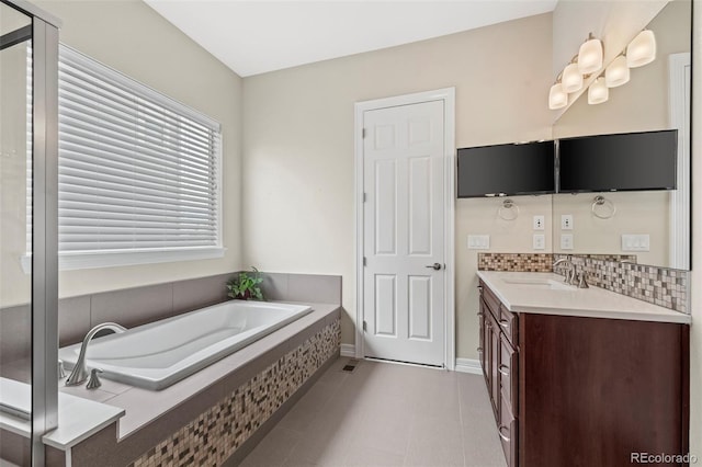 bathroom featuring vanity, tile patterned flooring, decorative backsplash, and tiled bath