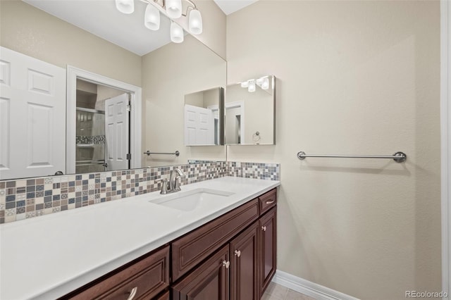 bathroom featuring an enclosed shower, vanity, and tasteful backsplash