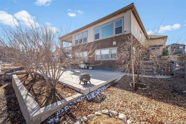 back of house with a fire pit and a patio