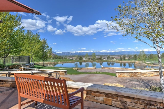 view of patio / terrace with a water and mountain view