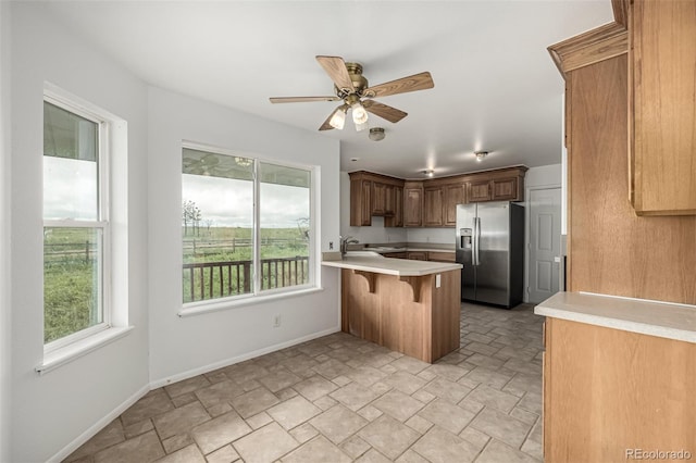 27190 Private Road 139, Agate, CO 80101 - kitchen with stainless steel fridge, a peninsula, light countertops, ceiling fan, and a kitchen bar