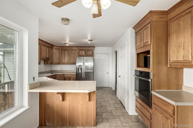 27190 Private Road 139, Agate, CO 80101 - kitchen featuring stainless steel appliances, stone finish flooring, a ceiling fan, a peninsula, and light countertops