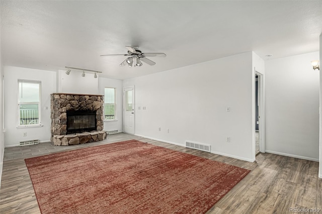 27190 Private Road 139, Agate, CO 80101 - unfurnished living room with a stone fireplace, ceiling fan, and wood finished floors