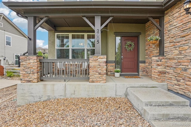 2605 Gray Wolf Loop, Broomfield, CO 80023 - doorway to property featuring a porch, stone siding, and stucco siding