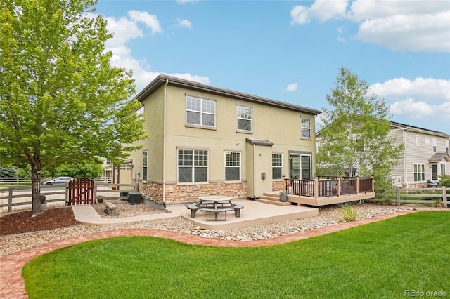 2605 Gray Wolf Loop, Broomfield, CO 80023 - rear view of property featuring stone siding, a deck, stucco siding, and a patio
