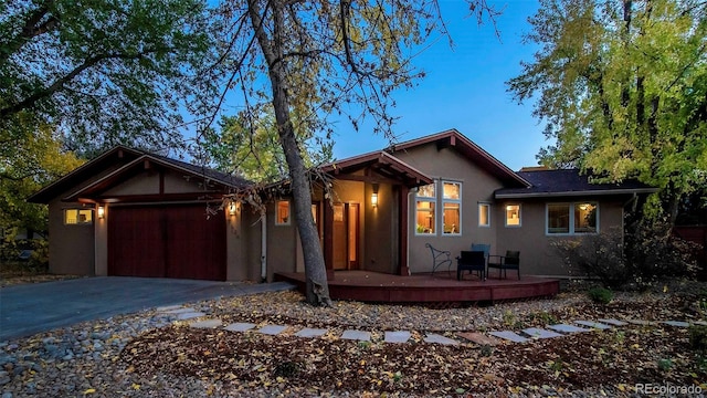 view of front of house with driveway, an attached garage, and stucco siding