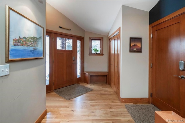 foyer entrance featuring light wood finished floors and vaulted ceiling