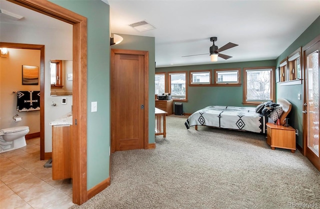 bedroom featuring visible vents, ensuite bathroom, light carpet, light tile patterned flooring, and baseboards