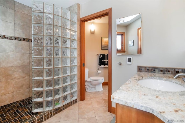 full bathroom with a walk in shower, tile patterned flooring, toilet, vanity, and baseboards