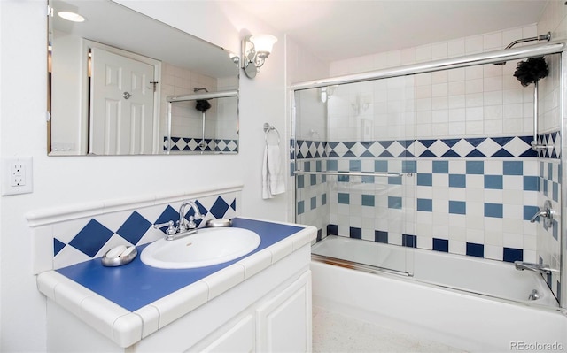 full bathroom featuring speckled floor, combined bath / shower with glass door, and vanity