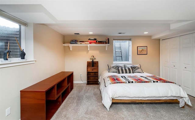 carpeted bedroom with visible vents, a closet, and recessed lighting