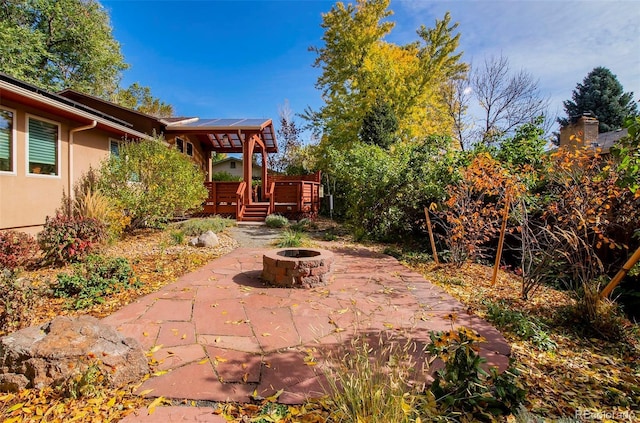 view of patio featuring a deck and a fire pit