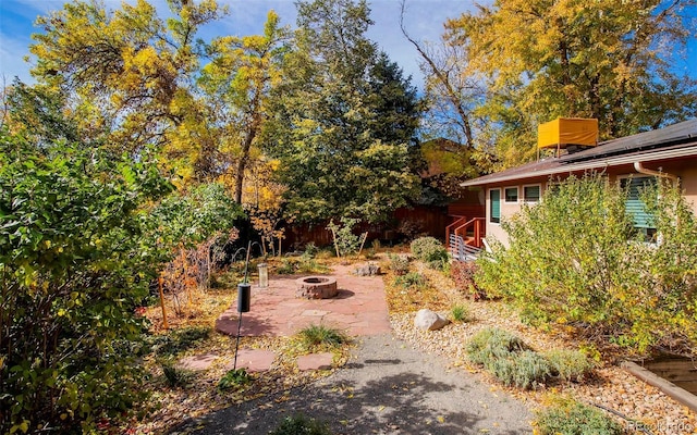 view of yard featuring a patio area, fence, and a fire pit