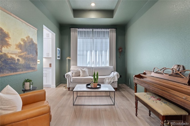 3147 S Quaker St, Morrison, CO 80465 - living area with light wood-style flooring, a textured wall, and a tray ceiling
