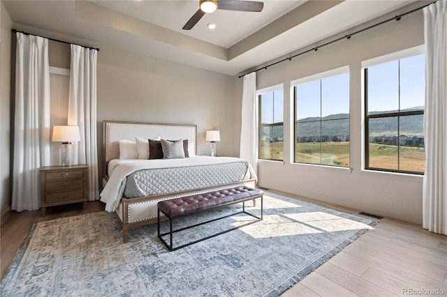 3147 S Quaker St, Morrison, CO 80465 - bedroom with wood finished floors, a mountain view, a tray ceiling, recessed lighting, and a ceiling fan